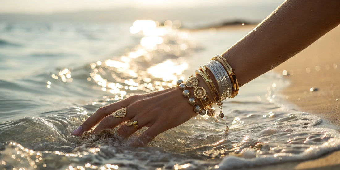 Gold jewelry on elegant hand in ocean waves at golden hour sunset