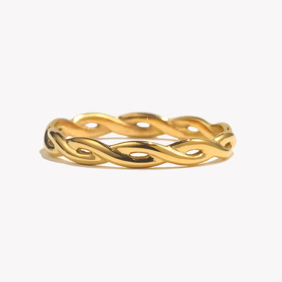 Gold ring with a wavy design on a white background