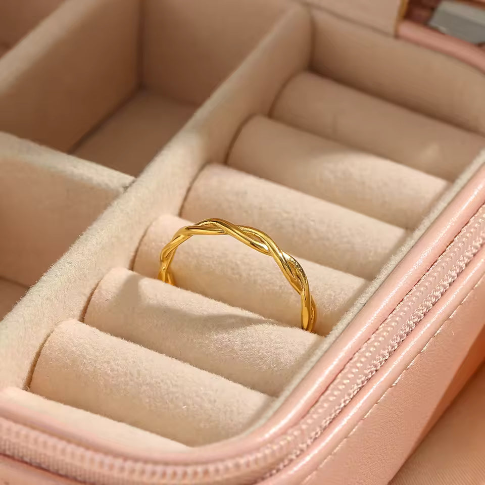 Gold ring in a pink jewelry box with soft focus background