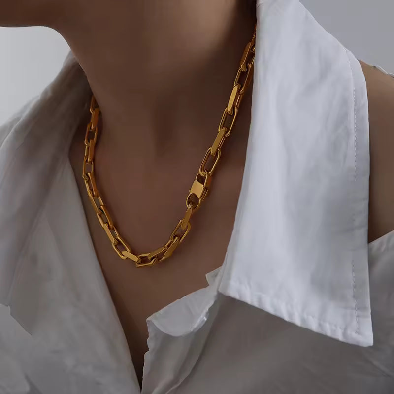 Gold chain necklace worn by a person with a white shirt
