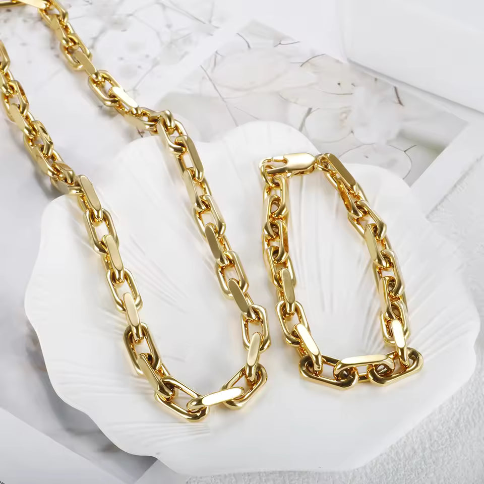 Gold chain necklace on a white shell with a white background