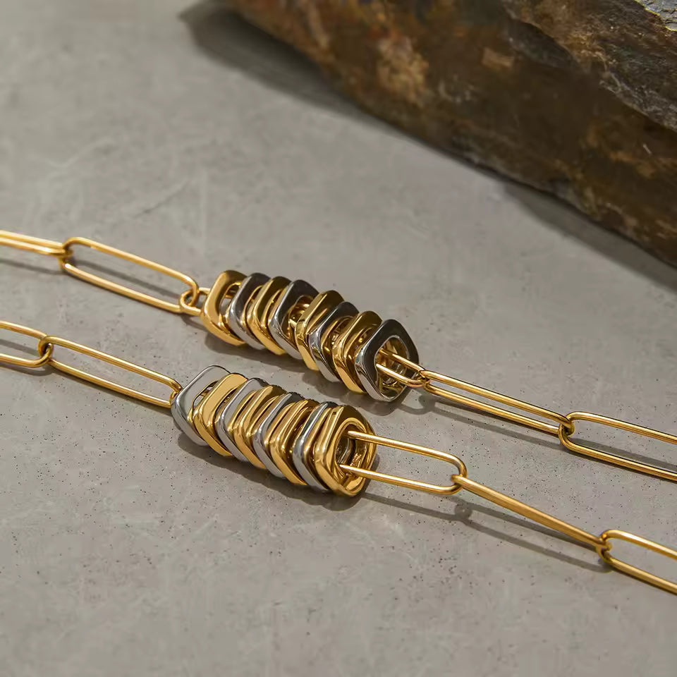 Gold and silver beaded necklace on a textured surface