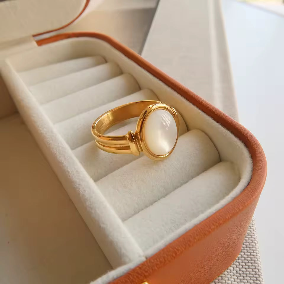 Gold ring with a white stone in an open jewelry box