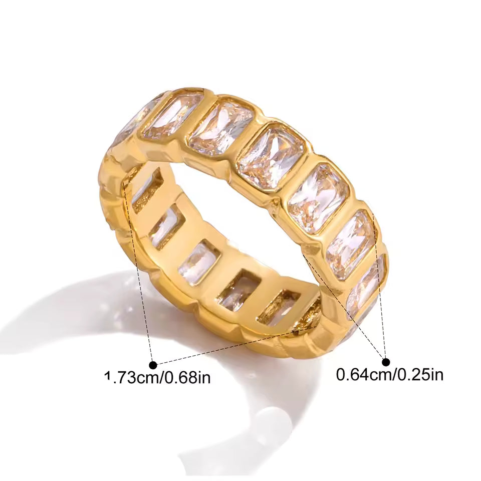 Gold ring with clear gemstones on a white background