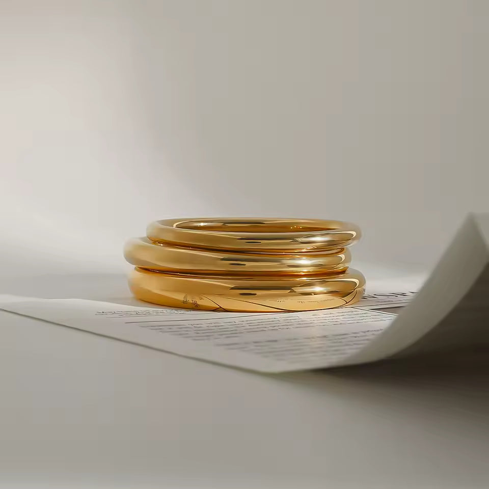 Stack of gold Bracelets on a white surface