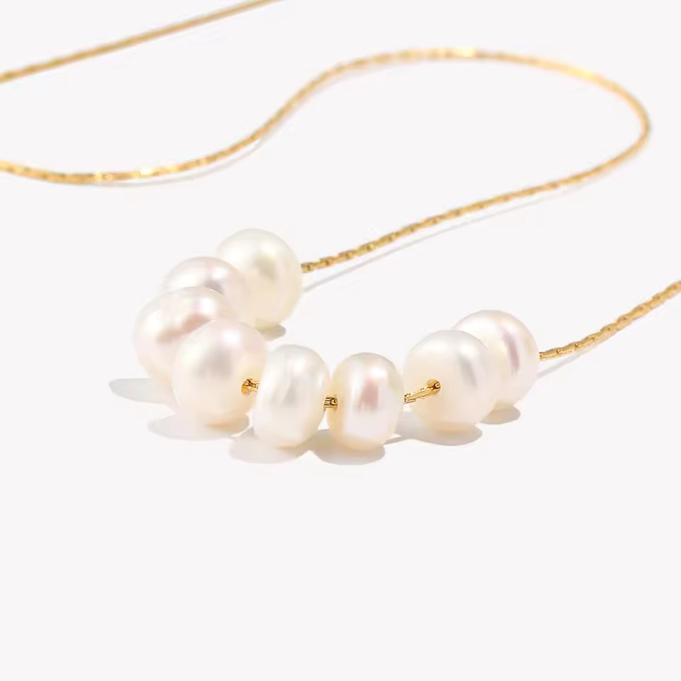 Pearl necklace with gold chain on a white background