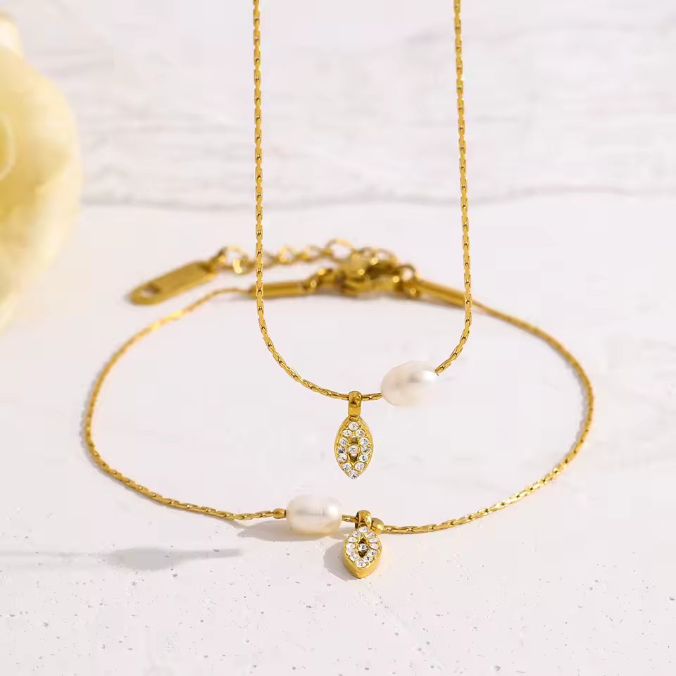 Gold bracelet with heart-shaped charm on a light background