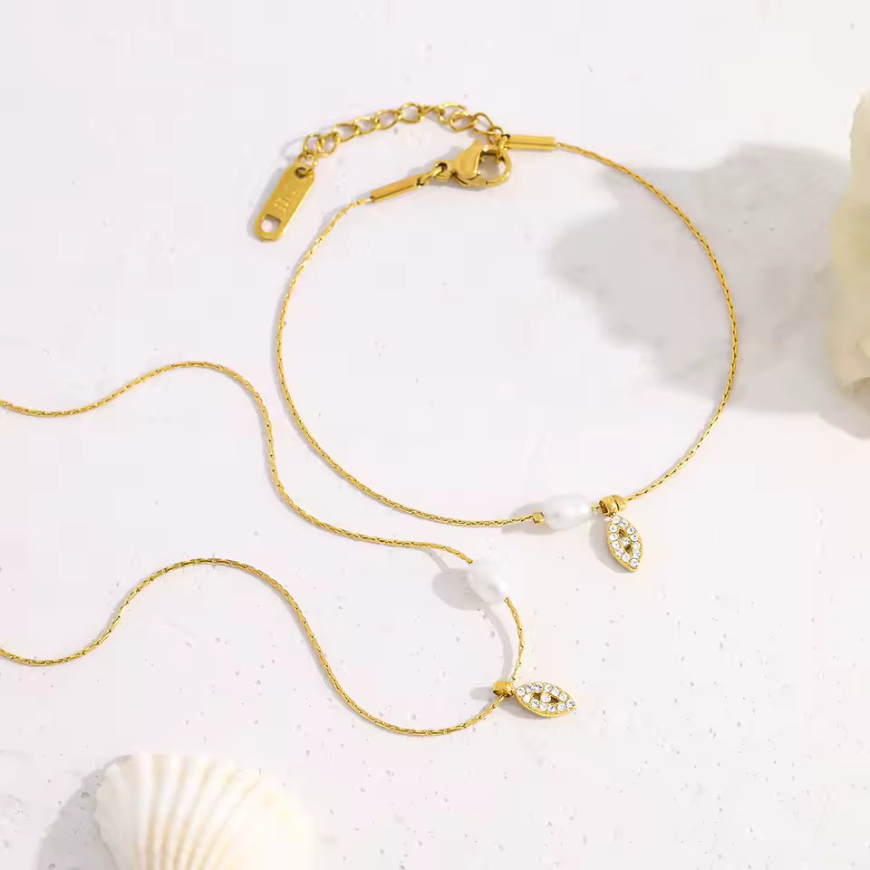 Gold necklace with pendant on a white surface