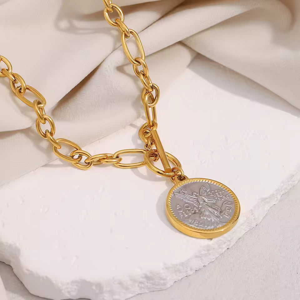 Gold Coin Pendant Necklace on stone