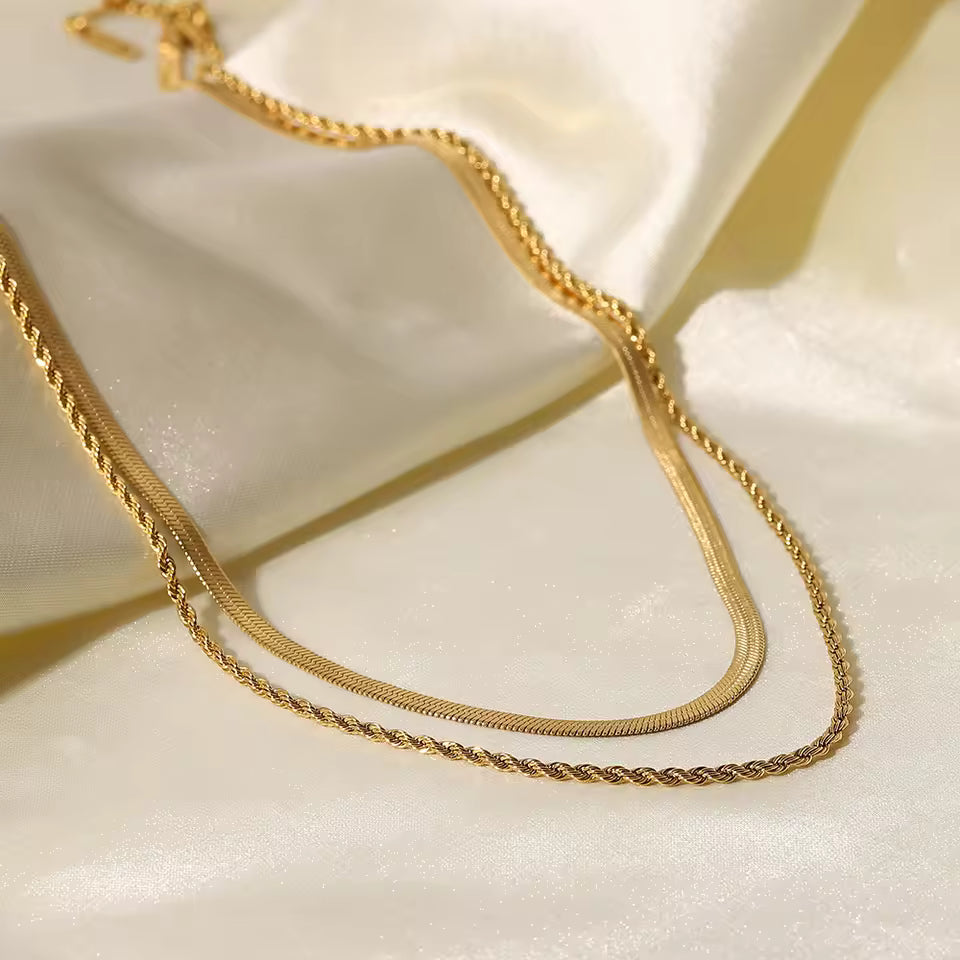 Gold chain necklace on a white fabric background