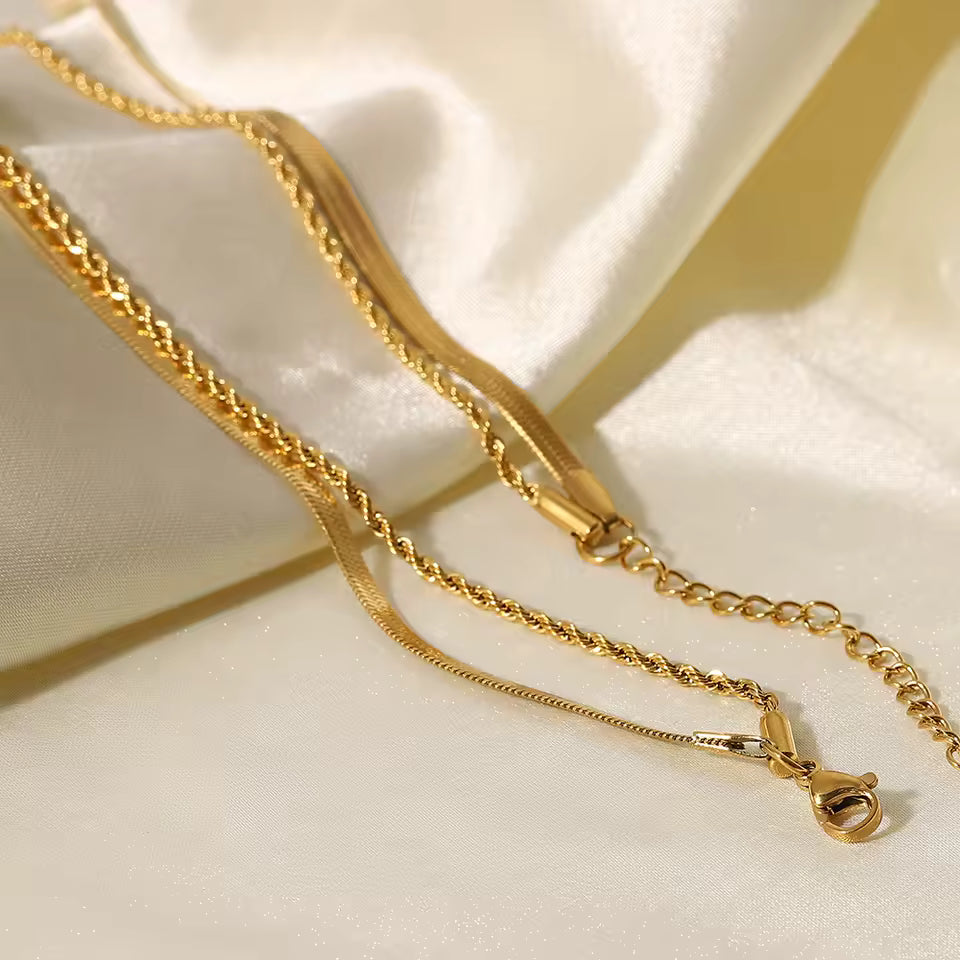 Gold chain necklace on a white fabric background