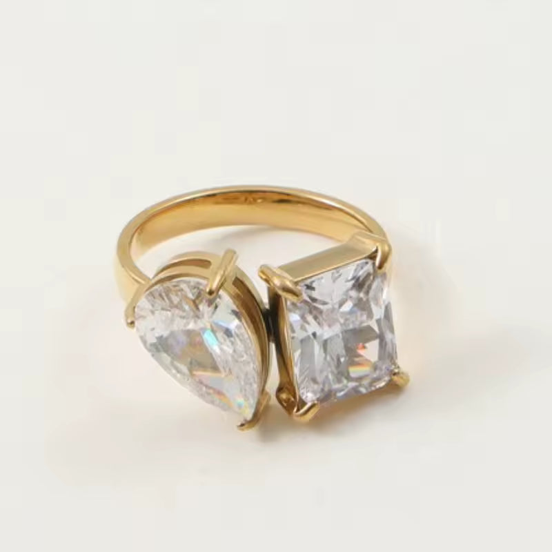 Gold ring with two cubic zirconia's on white background