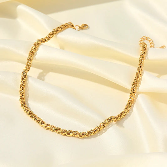Gold chain necklace on a soft beige fabric background
