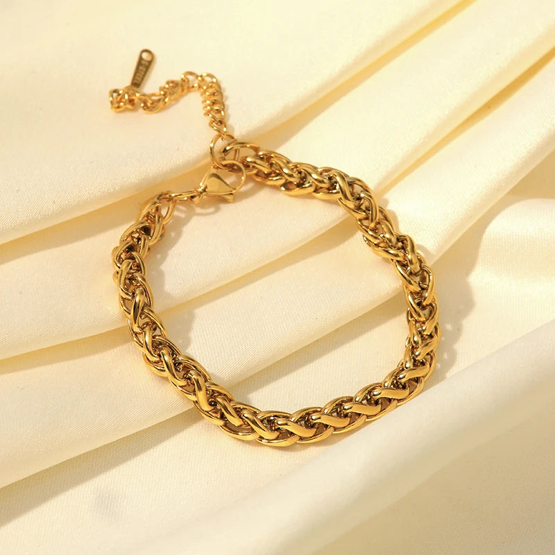 Gold chain bracelet on a light beige background