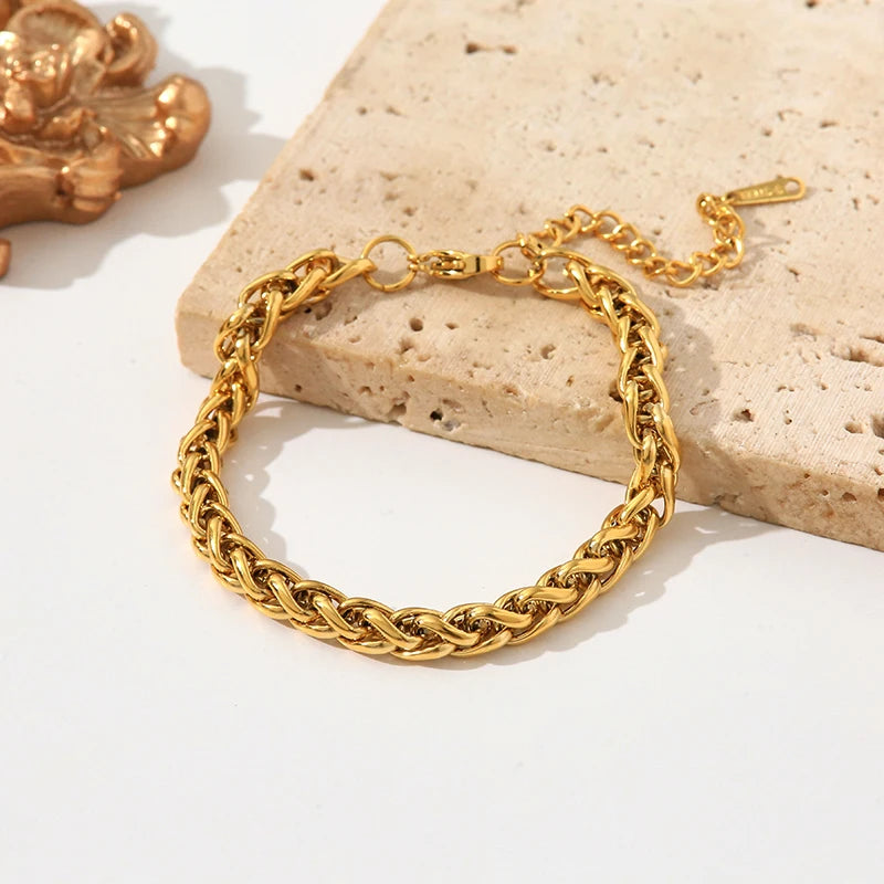Gold chain bracelet on a textured stone surface