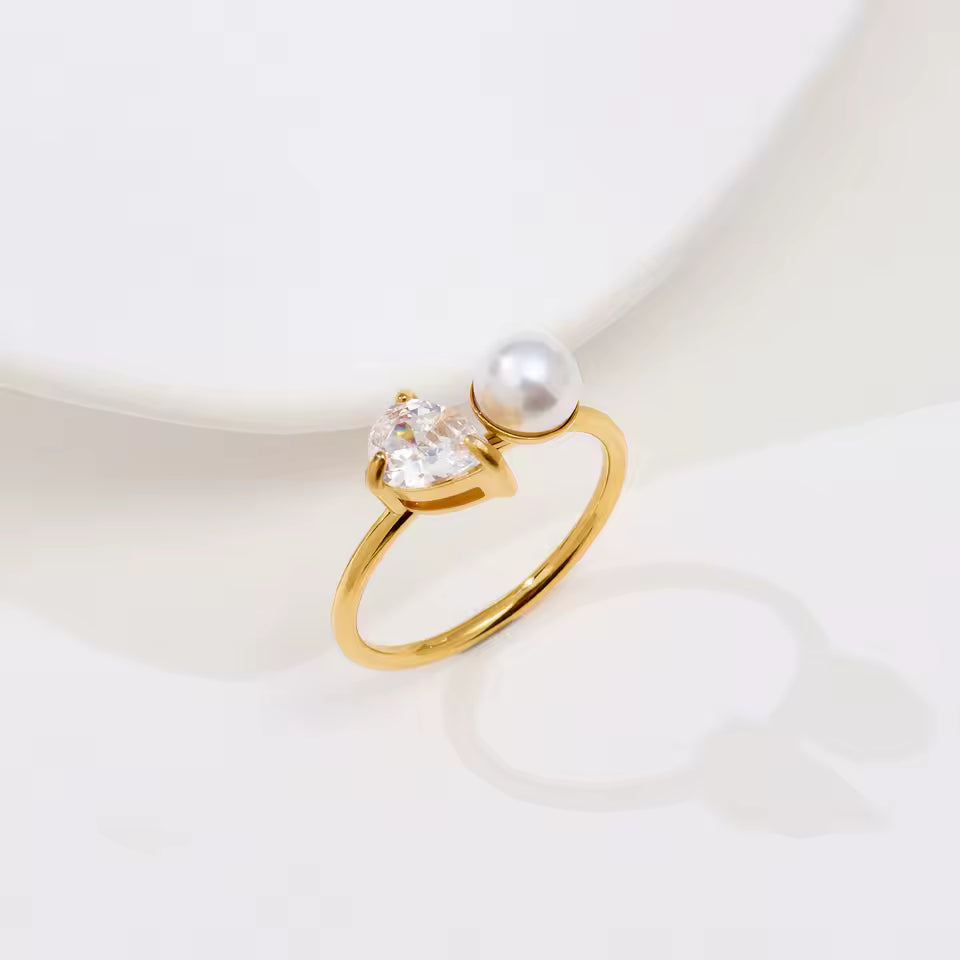 Ring with pearl and diamond setting on plain background