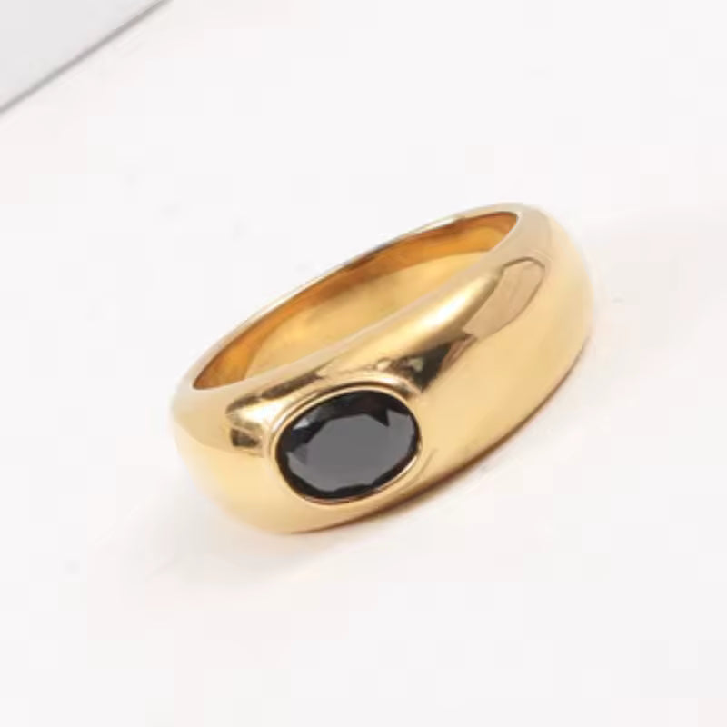 Gold ring with a black gemstone on a white background