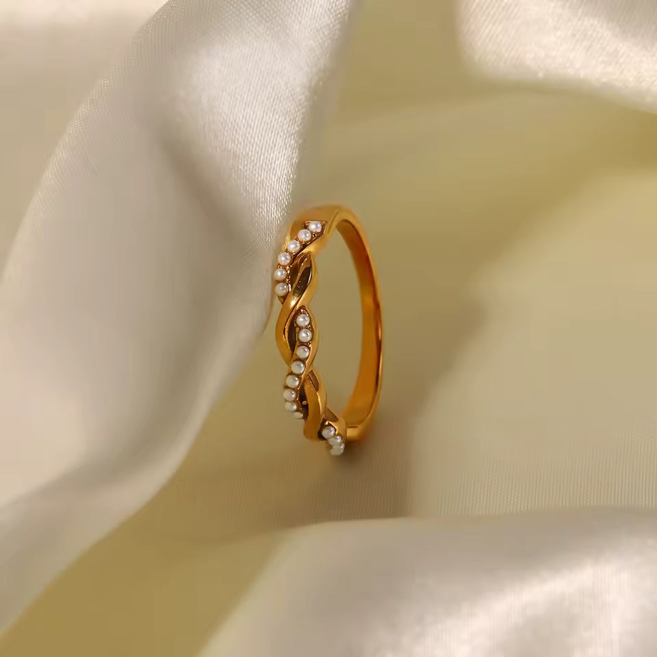 Gold ring with small diamonds on a beige fabric background