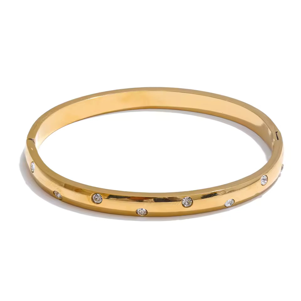Gold bangle with small diamonds on a white background