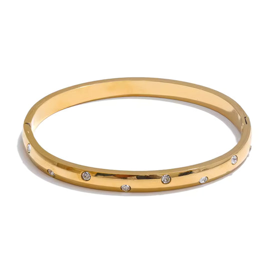 Gold bangle with small diamonds on a white background