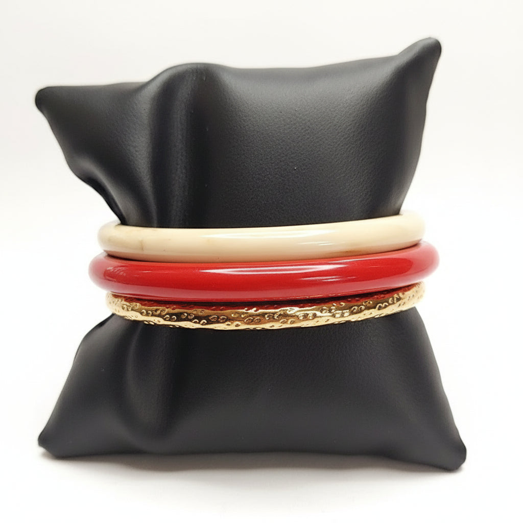 Set of bracelets on a black cushion with a beige background