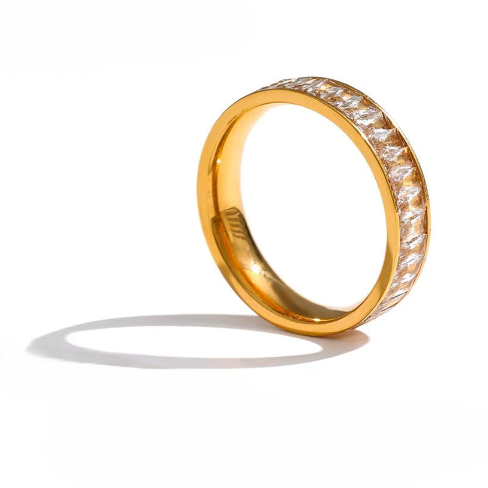 Gold ring with diamond accents on a white background