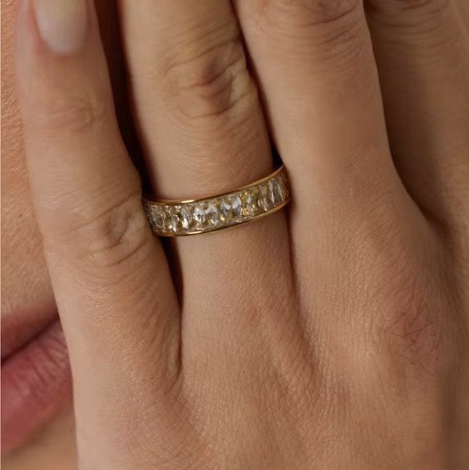 Gold ring with diamonds on a person's finger