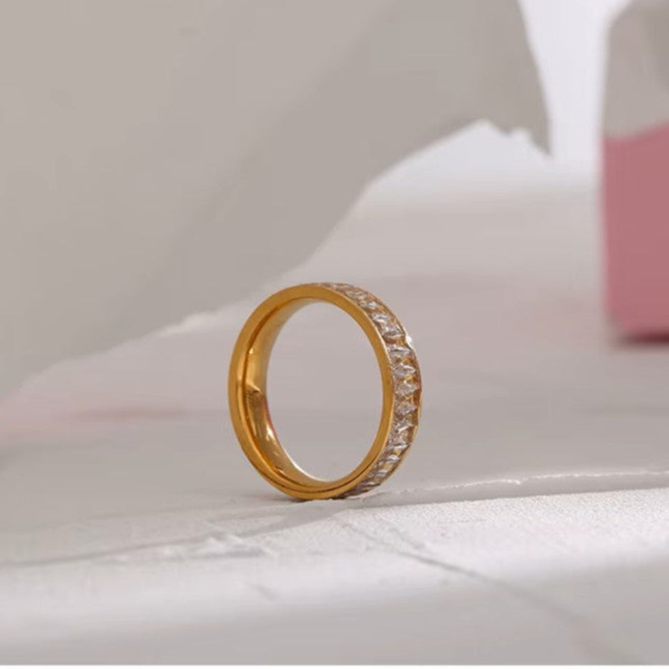 Gold ring with diamonds on a white surface