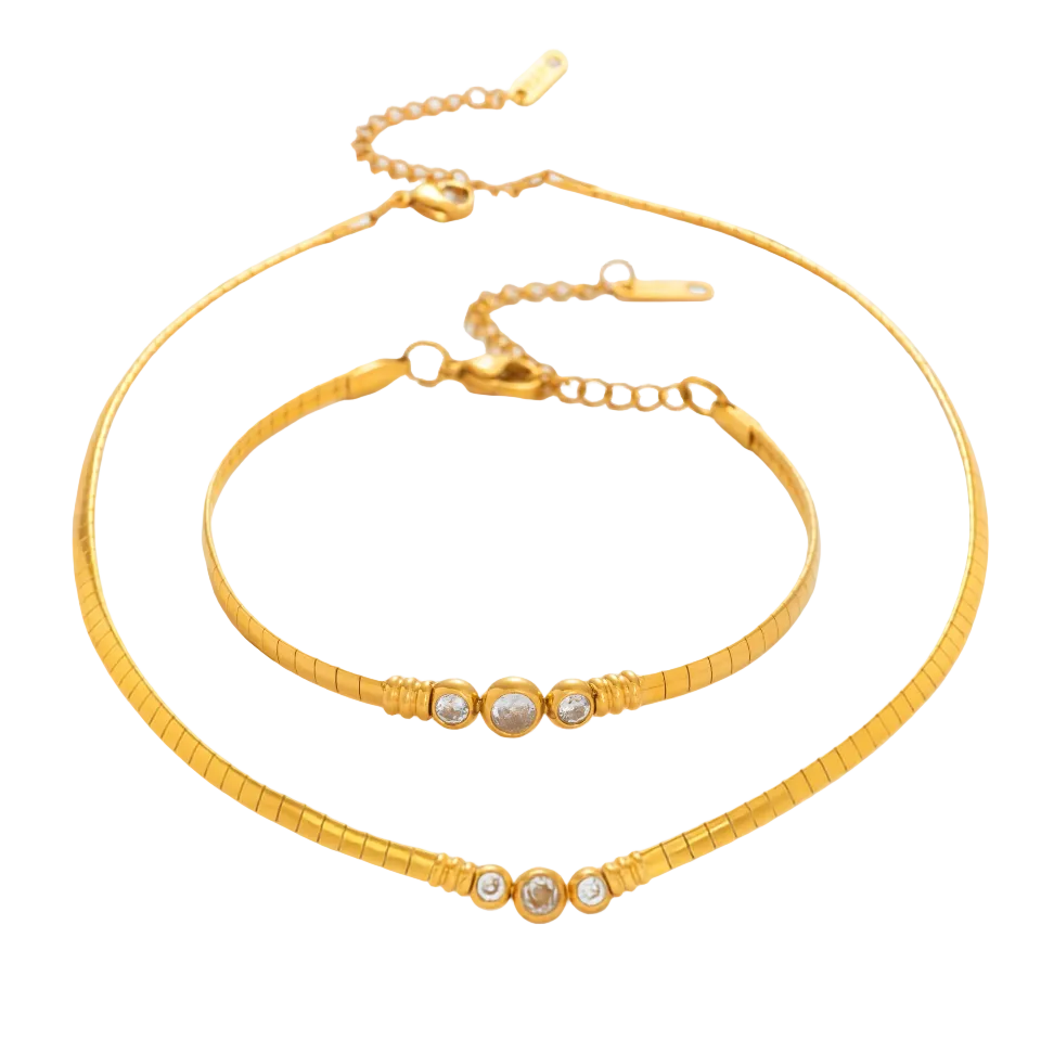 Gold necklace and bracelet set on a white background