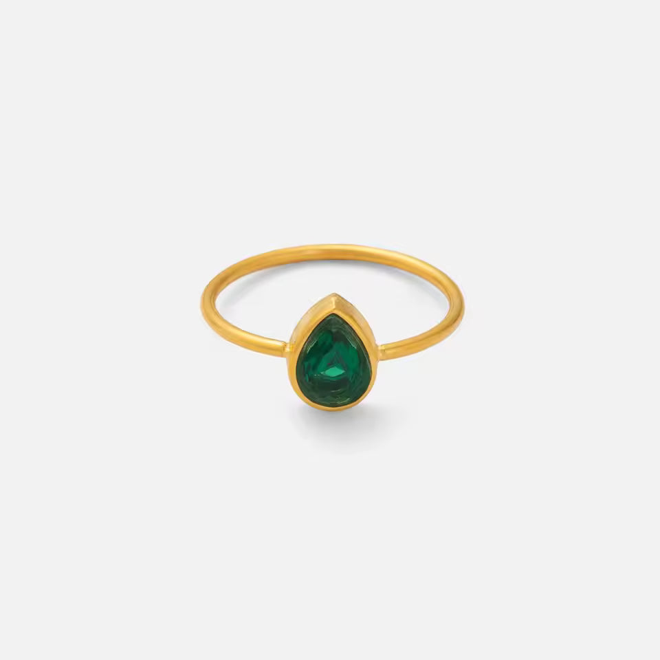 Gold ring with a green gemstone on a white background
