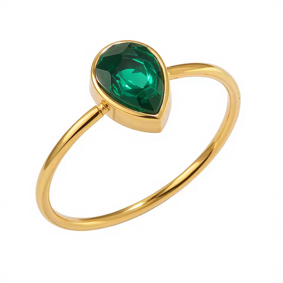 Gold ring with a green gemstone on a white background