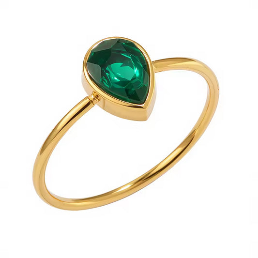 Gold ring with a green gemstone on a white background