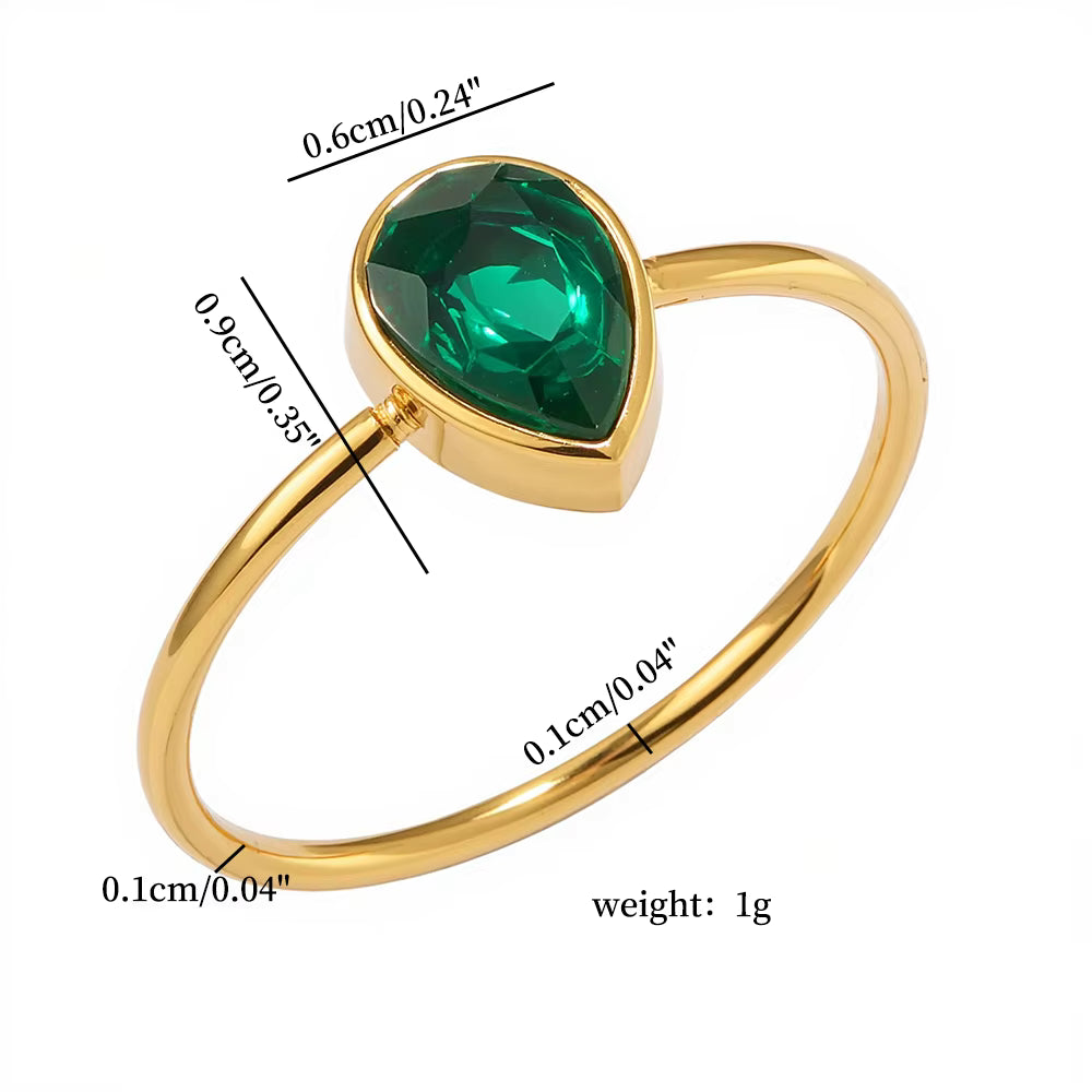 Gold ring with a green gemstone, showing measurements on a white background