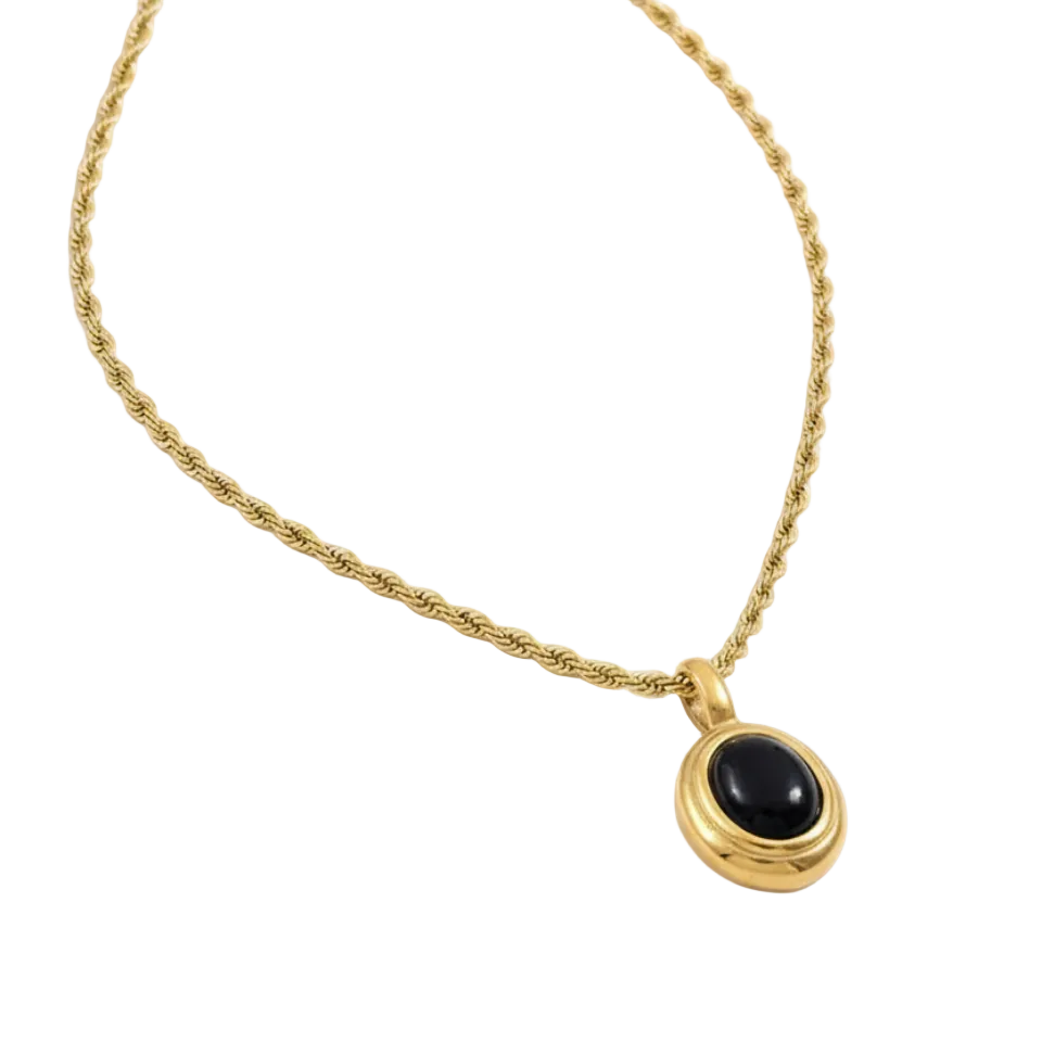 Gold necklace with a black pendant on a white background