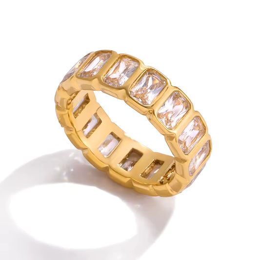 Gold ring with rectangular gemstones on a white background