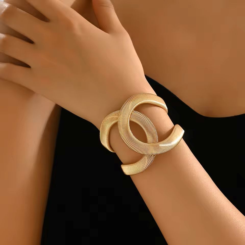 Gold bracelet on a wrist with a blurred background