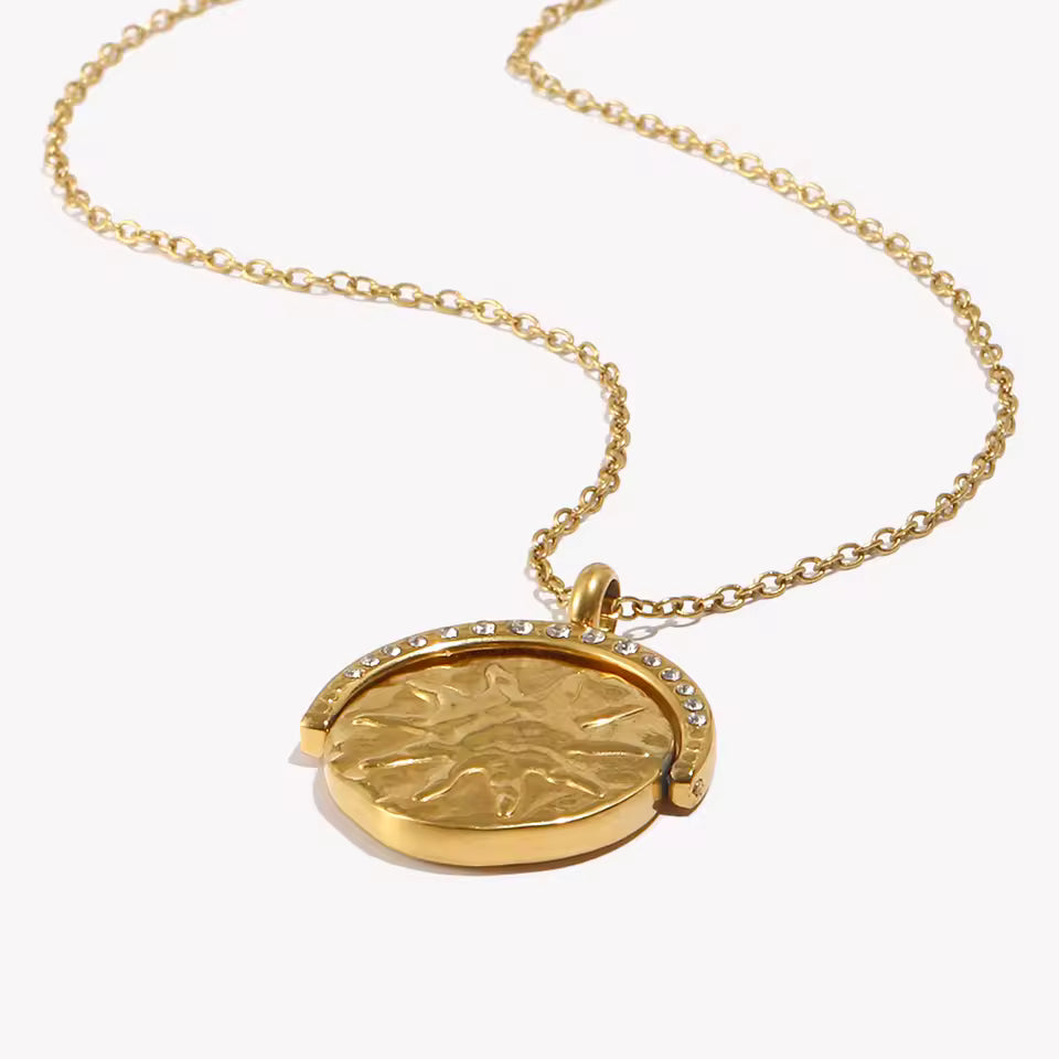 Gold necklace with a round pendant on a white background