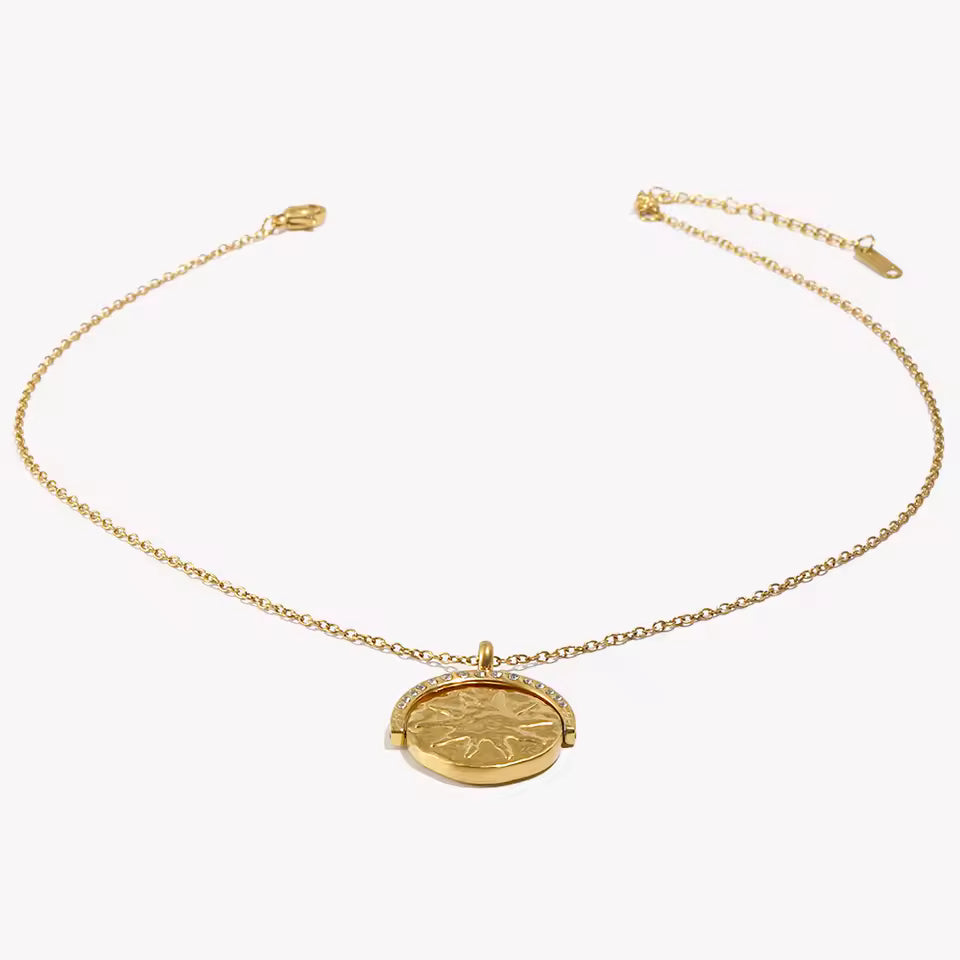 Gold necklace with a round pendant on a white background