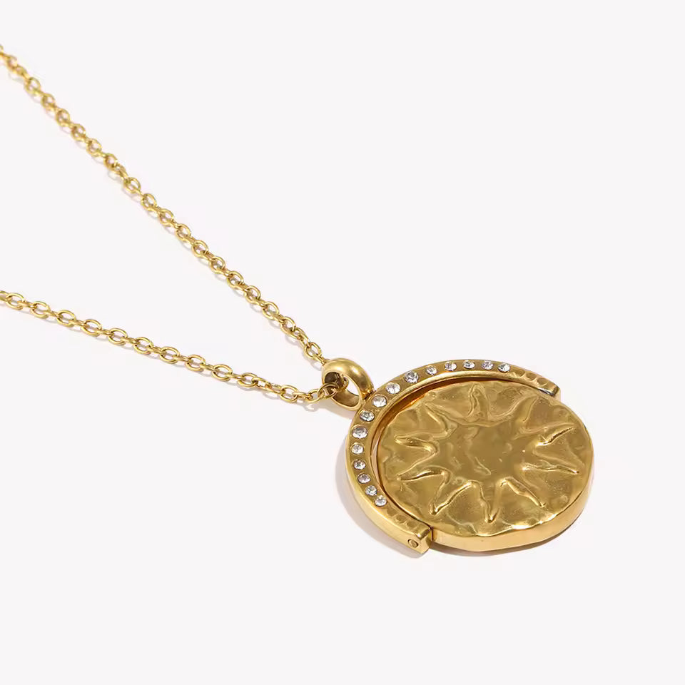 Gold necklace with a round pendant on a white background