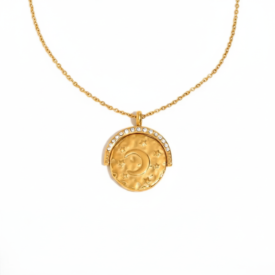 Gold necklace with a moon and star pendant on a white background