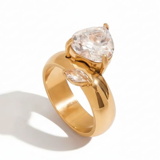 Gold ring with a pear-shaped diamond on a white background