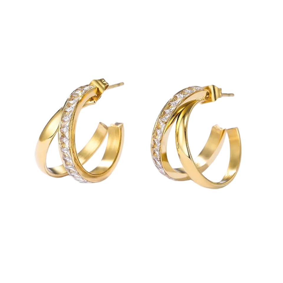 A pair of gold hoop earrings with a row of clear pavé-set stones on one side, displayed on a clean white background with soft shadows.