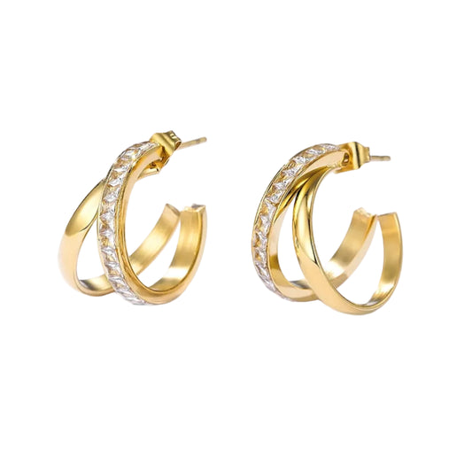 A pair of gold hoop earrings with a row of clear pavé-set stones on one side, displayed on a clean white background with soft shadows.