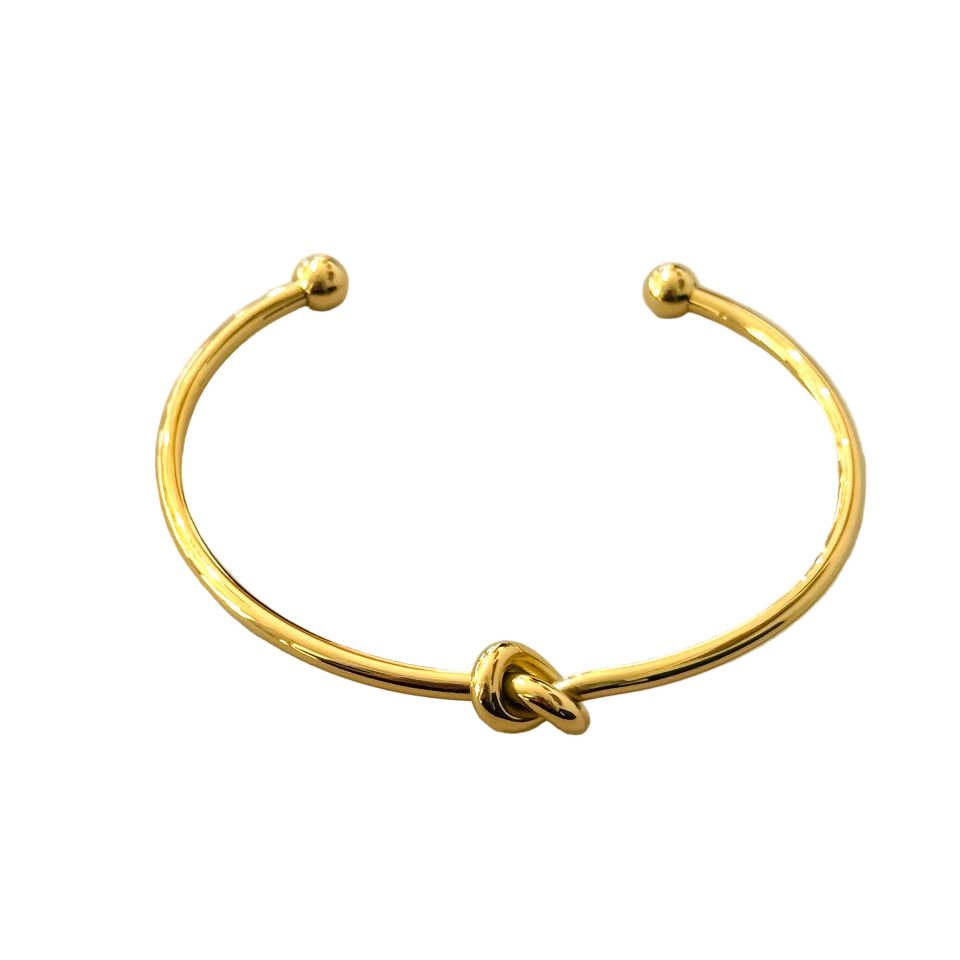 A gold-plated open cuff bangle bracelet with a knotted center detail and rounded end tips, shown on a plain white background.