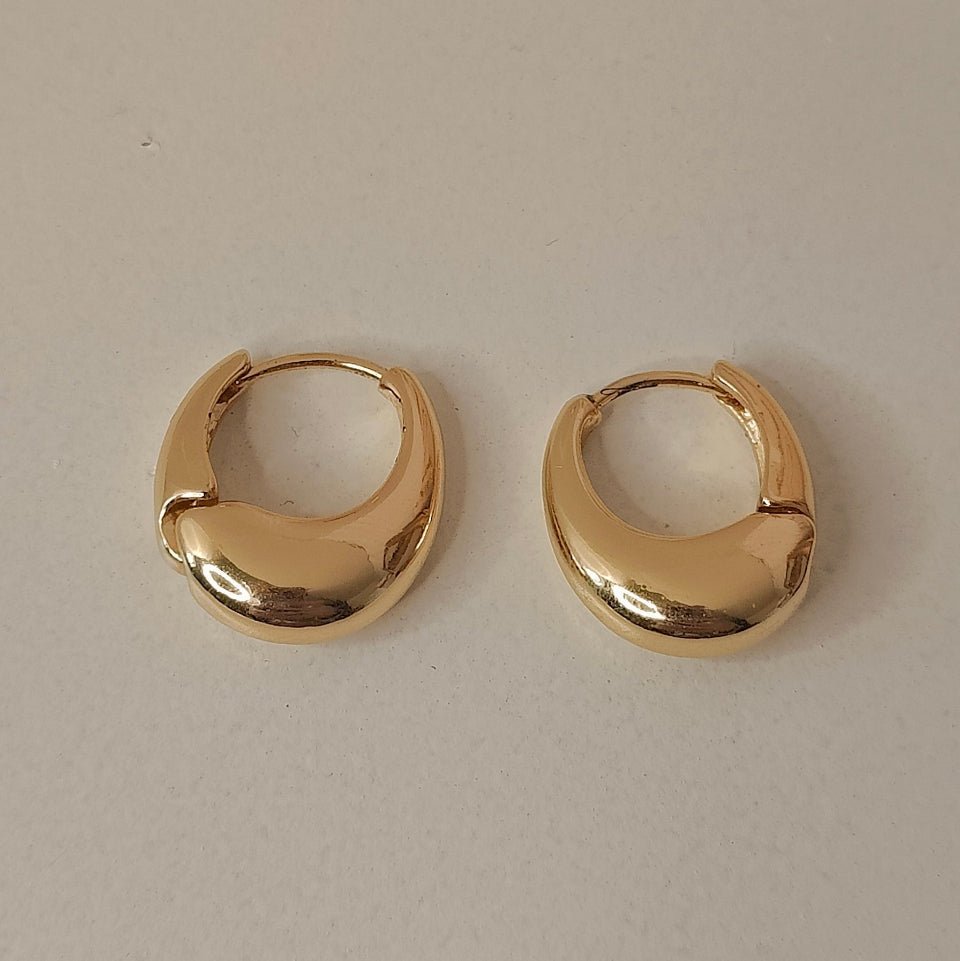 Gold hoop earrings on a light gray background