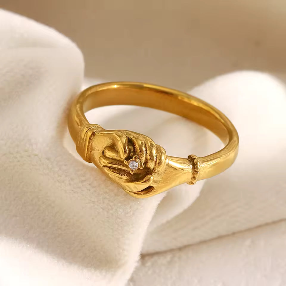 Gold ring with a diamond on a beige fabric background
