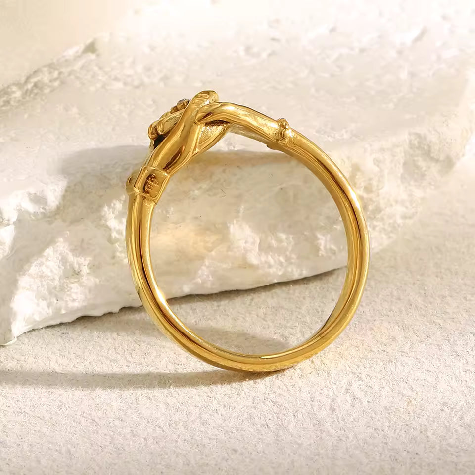 Gold bracelet with a unique design on a textured white surface