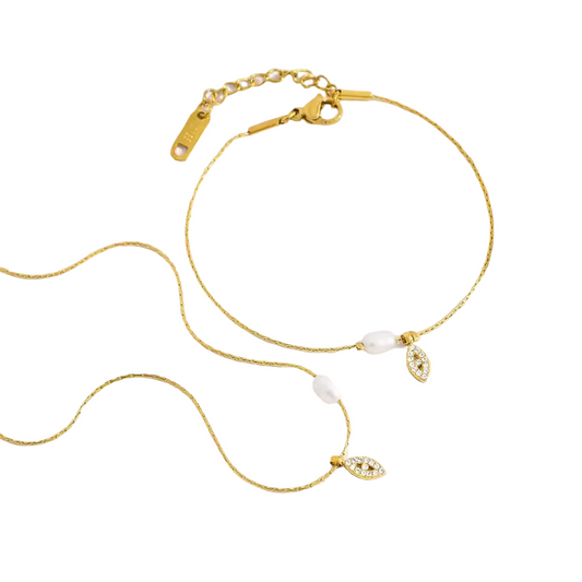 Gold necklace with pearl and gemstone accents on a white background