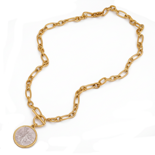 Gold chain bracelet with a round pendant on a white background