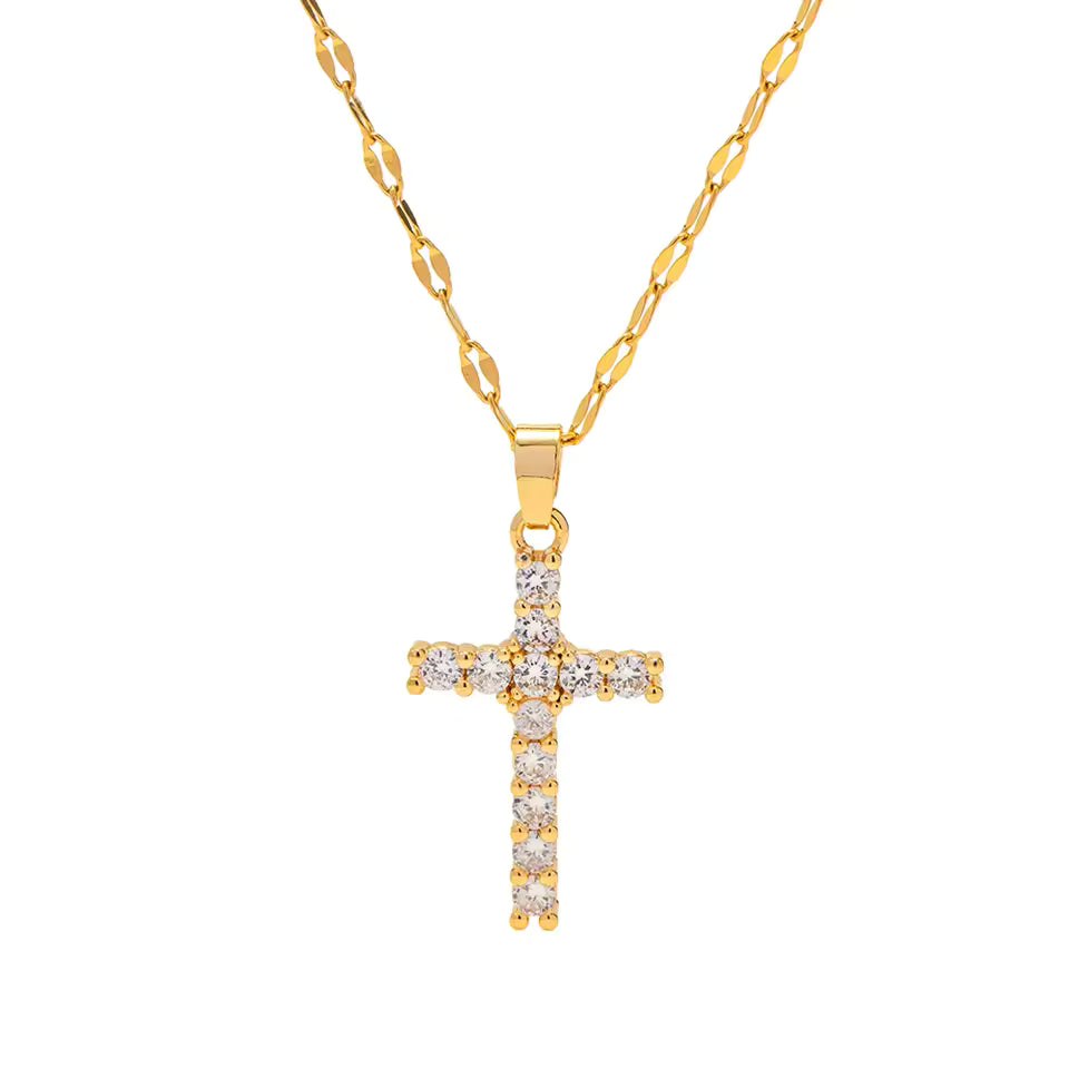 Gold cross pendant with cubic zirconia on a gold chain against a white background